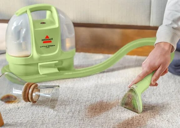 Cleaning a coffee spill on a light carpet with the BISSELL Little Green Mini
