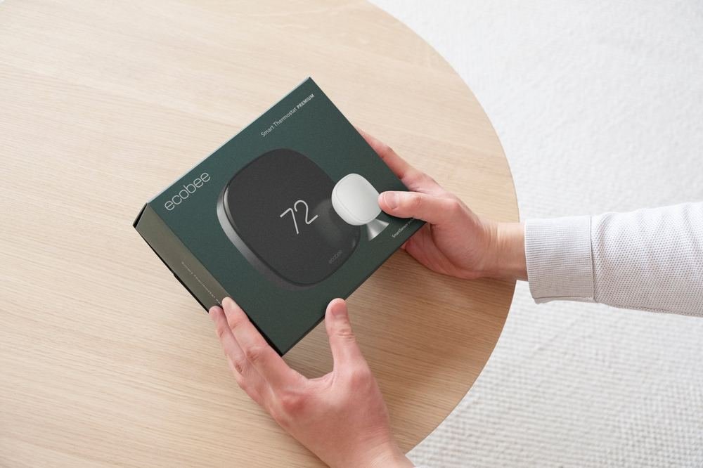 Hands holding the ecobee Smart Thermostat Premium retail box